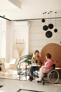 Una reunión de negocios entre dos mujeres, una en silla de ruedas, en una sala moderna y elegante.